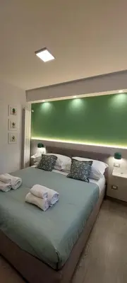 a bedroom with a large bed with a green wall at The Golden Pyramid in Rome