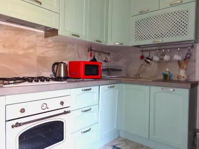 a kitchen with green cabinets and a red microwave at Happy Home Piramide Cestia Lussuoso Unico Esclusivo a Roma in Rome