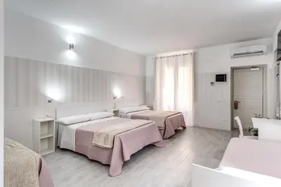 a hotel room with two beds and a mirror at AltaDomus Roma in Rome