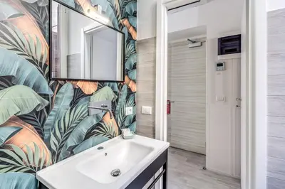 a bathroom with a sink and a leafy wallpaper at AltaDomus Roma in Rome