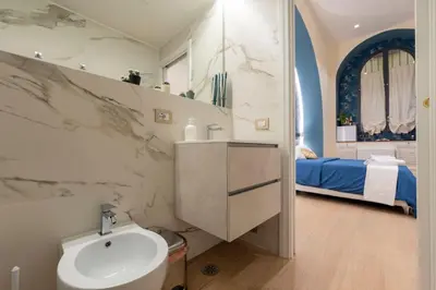 a bathroom with a sink and a bed in a room at Colosseo Romantic Suite in Rome