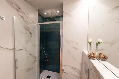 a bathroom with a walk in shower and a glass shower stall at Colosseo Romantic Suite in Rome