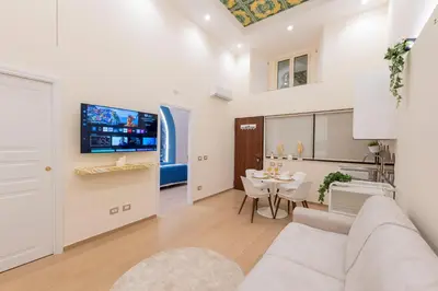 a living room with a couch and a dining room at Colosseo Romantic Suite in Rome