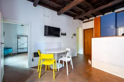 a dining room with a table and yellow chairs at maison pelliccia in Rome