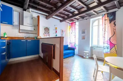 a kitchen with blue cabinets and a blue couch at maison pelliccia in Rome