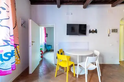 a dining room with a white table and yellow chairs at maison pelliccia in Rome