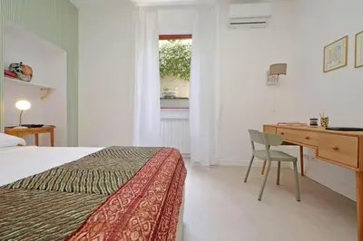 a bedroom with a bed and a desk and a window at Vatican apartment with parking in Rome