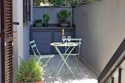 a table and chairs on a patio with a bottle of wine at Vatican apartment with parking in Rome