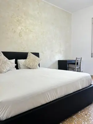 a bed with white sheets and pillows in a room at Valentina House in Rome