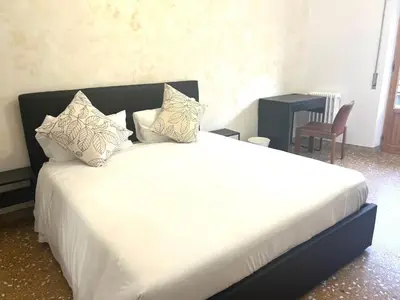 a bedroom with a large bed with white sheets and pillows at Valentina House in Rome