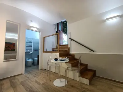 a living room with stairs and a table and a staircase at viaCatania16 in Rome