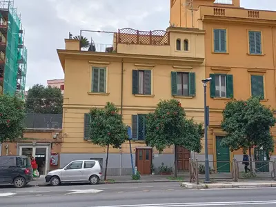 a yellow building with cars parked in front of it at viaCatania16 in Rome