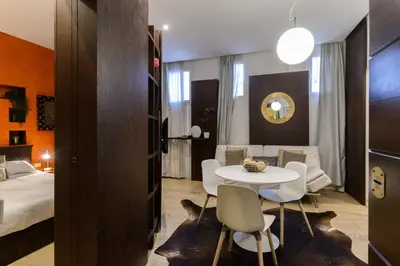 a room with a bed and a table and chairs at Trastevere Charme in Rome