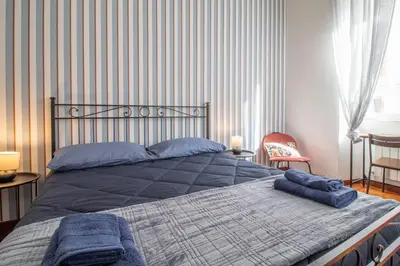 a bedroom with a large bed with blue pillows on it at Ezio House in Rome