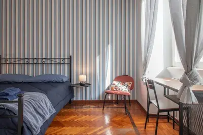 a bedroom with a bed and a desk and a chair at Ezio House in Rome