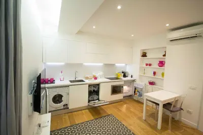 a kitchen with white cabinets and a washer and dryer at Apartment Via del Corso in Rome