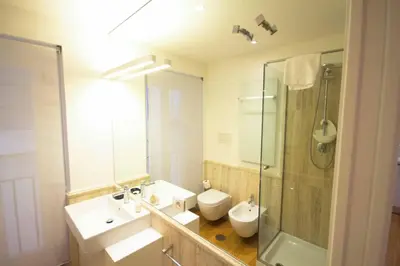 a bathroom with two sinks and a shower and a toilet at Apartment Via del Corso in Rome