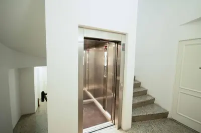 a glass elevator in a hallway with stairs at Apartment Via del Corso in Rome