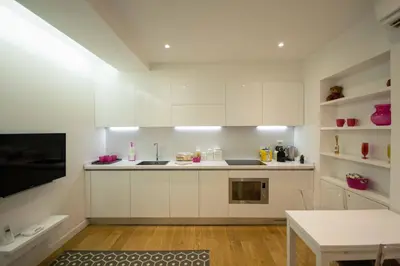 a white kitchen with white cabinets and a table at Apartment Via del Corso in Rome