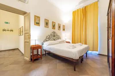a bedroom with a bed and a yellow curtain at 3 House - by Ghor in Rome