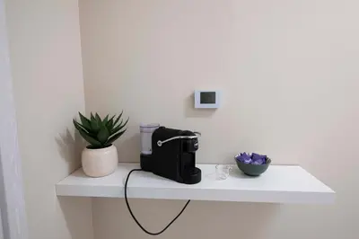 a black appliance sitting on a white shelf in a room at Le stanze sui musei vaticani in Rome