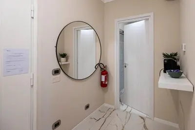 a bathroom with a mirror and a red fire extinguisher at Le stanze sui musei vaticani in Rome