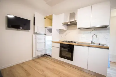 a kitchen with white cabinets and a sink at ODESCALCHI LOFT in Rome