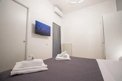 a bedroom with white towels on a bed with a tv at ODESCALCHI LOFT in Rome