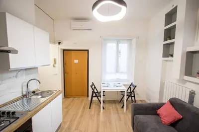 a kitchen and living room with a table and chairs at ODESCALCHI LOFT in Rome