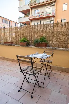 a table and chair on a patio with a fence at ODESCALCHI LOFT in Rome