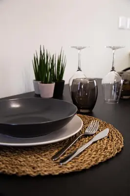 a table with a black plate and silverware on a table at Bright apartment near San Pietro in Rome