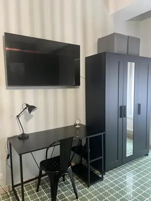 a black desk with a lamp and a tv on a wall at Bright apartment near San Pietro in Rome