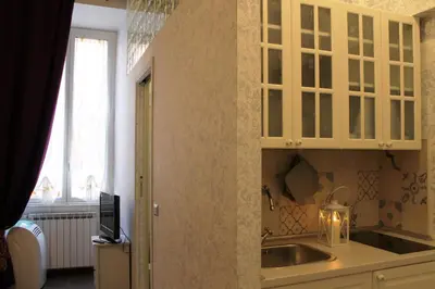 a kitchen with white cabinets and a sink and a window at Vatican Santamaura 39 in Rome