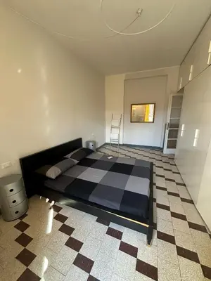 a bedroom with a bed and a checkered floor at Maison San Lorenzo Roma in Rome