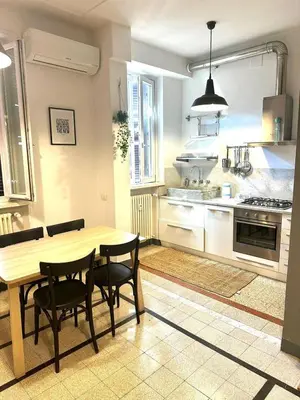 a kitchen with a wooden table and chairs in it at Maison San Lorenzo Roma in Rome