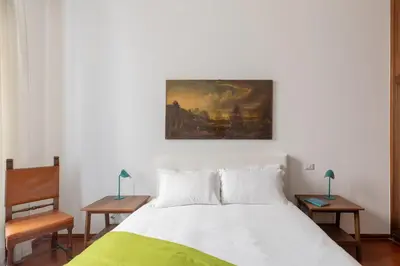 a bedroom with a bed and a painting on the wall at iFlat Elegant 3 bedroom apt near the Pantheon in Rome