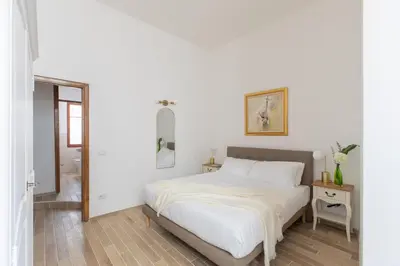 a white bedroom with a bed and a table at iFlat Elegant 3 bedroom apt near the Pantheon in Rome