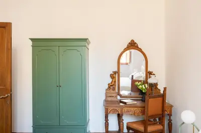 a green cabinet next to a mirror and a table at iFlat Elegant 3 bedroom apt near the Pantheon in Rome