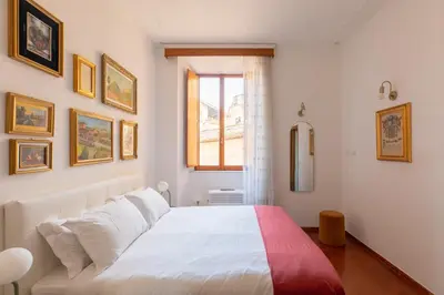 a bedroom with a white bed and a window at iFlat Elegant 3 bedroom apt near the Pantheon in Rome