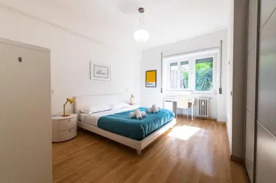 a white bedroom with a bed and a window at Leoncavallo Retreat in Rome