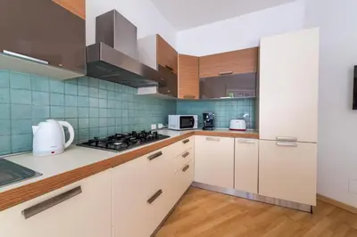 a kitchen with white cabinets and blue tiles at Leoncavallo Retreat in Rome