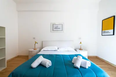 a bedroom with a large blue bed with towels on it at Leoncavallo Retreat in Rome