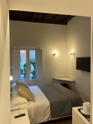 a bedroom with a large bed and a window at Maison Romana Trastevere Suites in Rome