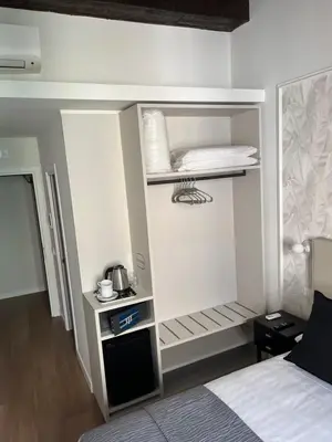 a small room with a bed and a kitchen at Maison Romana Trastevere Suites in Rome