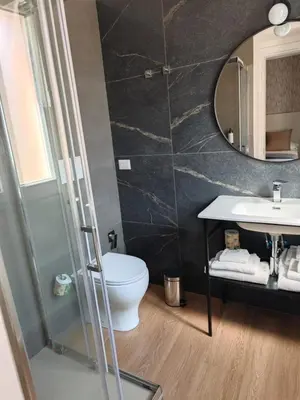 a bathroom with a toilet and a sink and a mirror at Maison Romana Trastevere Suites in Rome