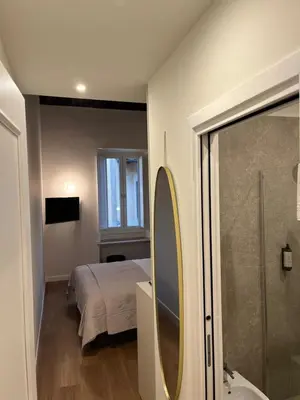 a bedroom with a bed and a bathroom with a shower at Maison Romana Trastevere Suites in Rome