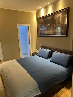 a bedroom with a large bed with two blue pillows at Aurelius Holiday Home in Rome