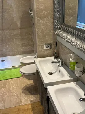 a bathroom with two sinks and a toilet and a mirror at Aurelius Holiday Home in Rome