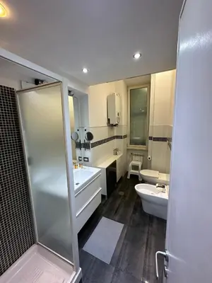 a bathroom with a shower and a toilet and a sink at Nova Domus Colosseo in Rome