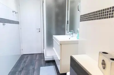 a white bathroom with a sink and a shower at Nova Domus Colosseo in Rome